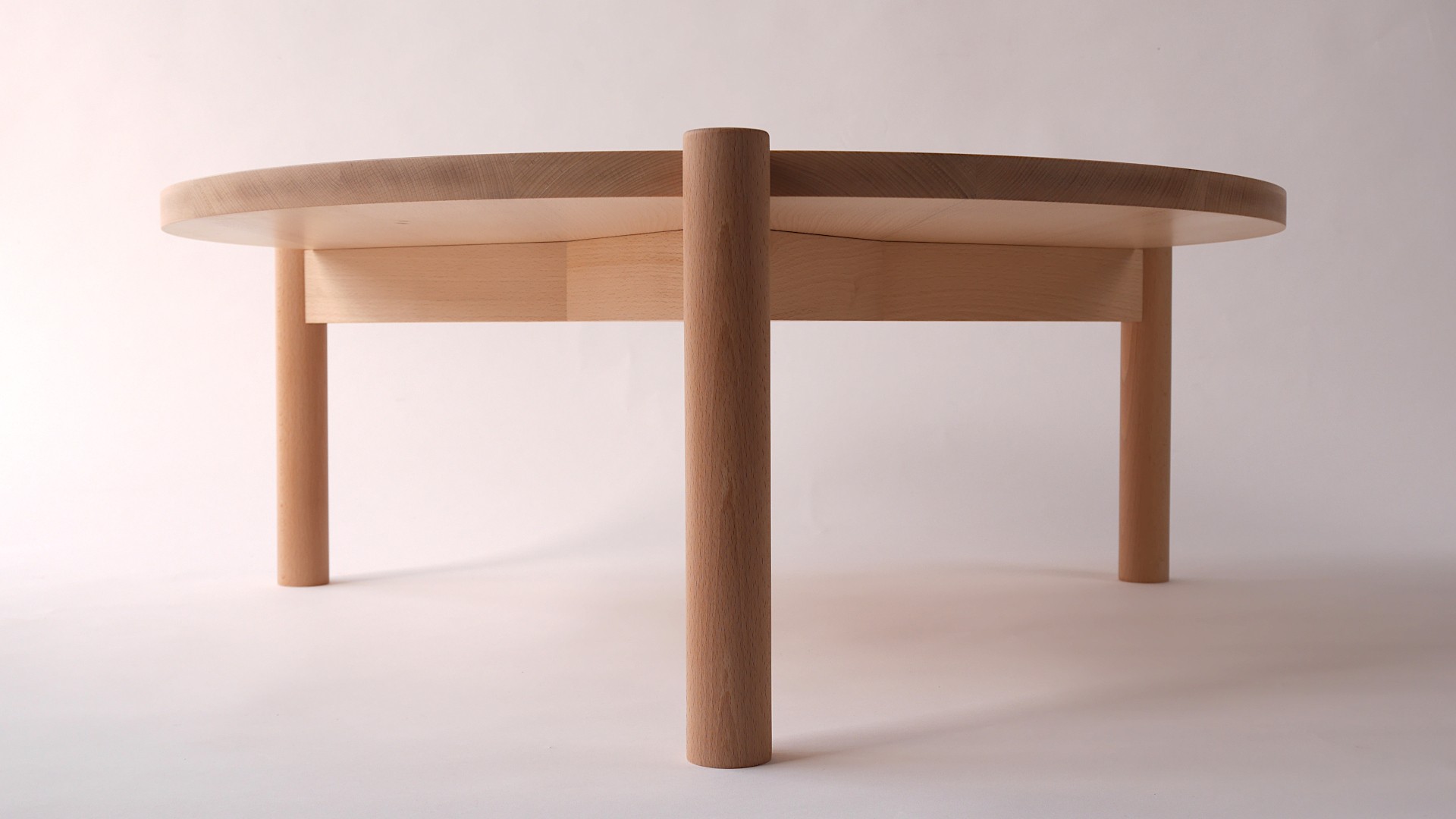 Table basse ronde en hêtre sur tripode vue de face